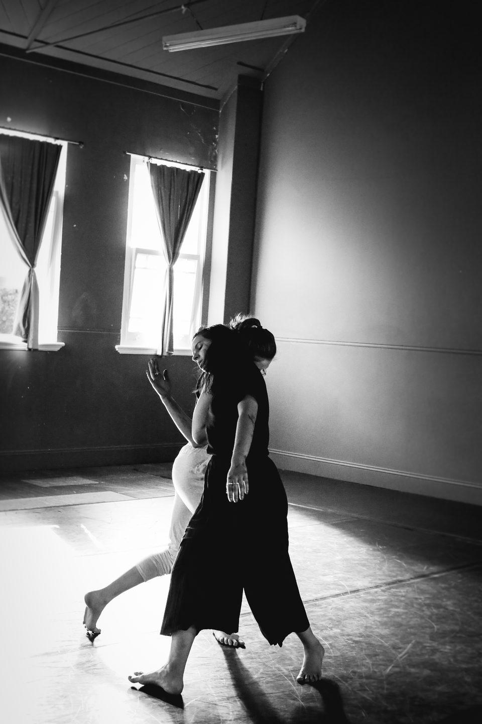 two dancers link at the elbow