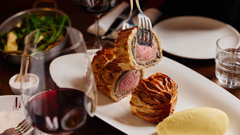 Beef Wellington with red wine and seasonal sides.